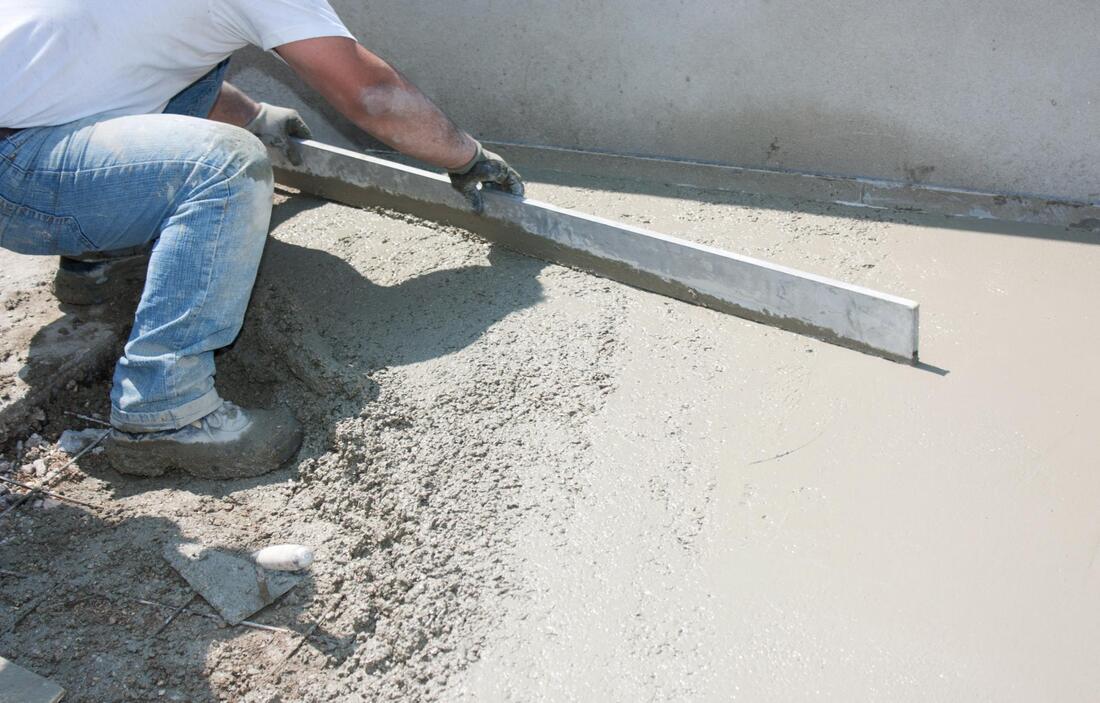 man flattening the concrete, and work is getting done!